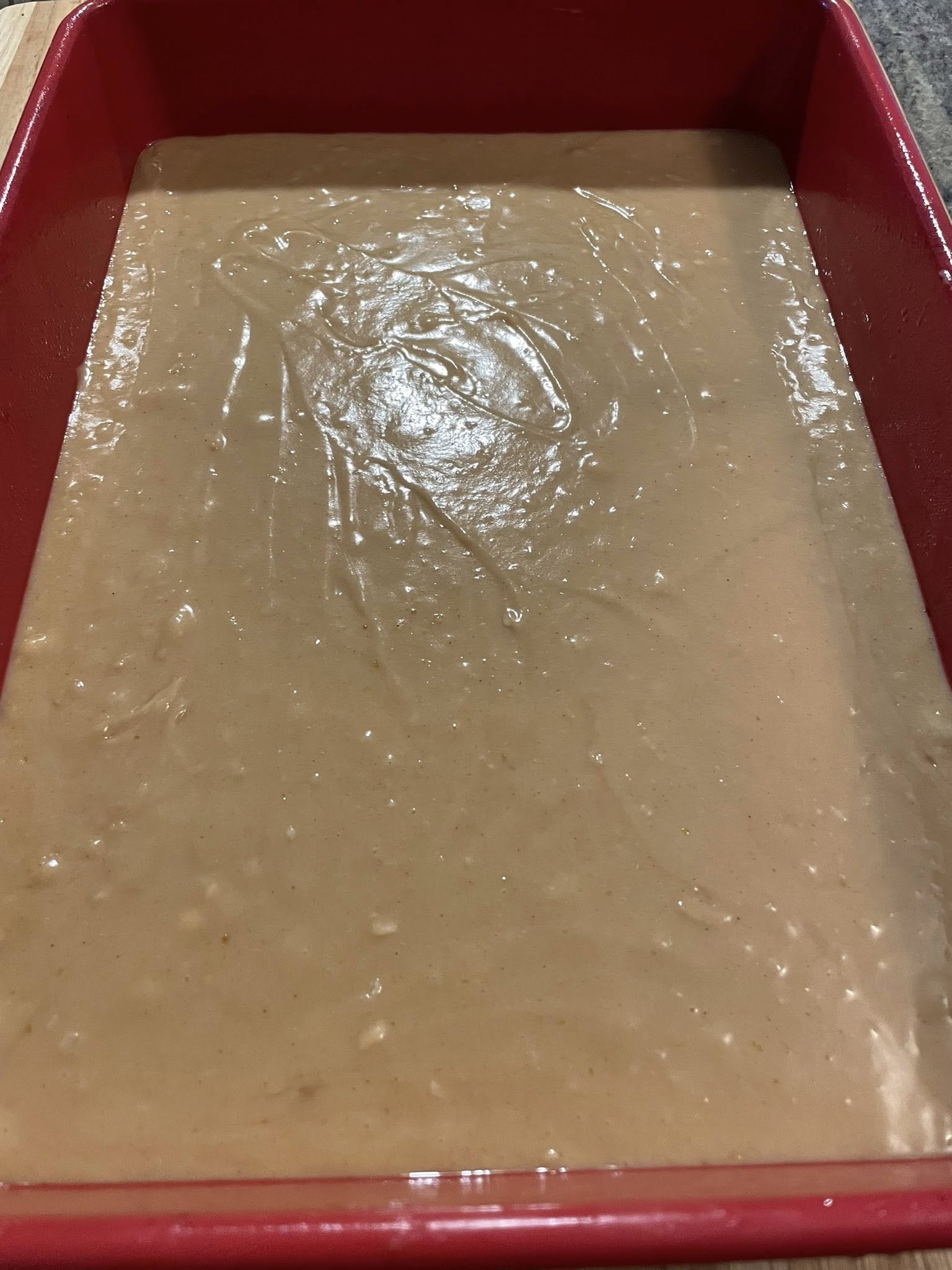 Batter for Biscoff mini cakes spread in pan before baking.