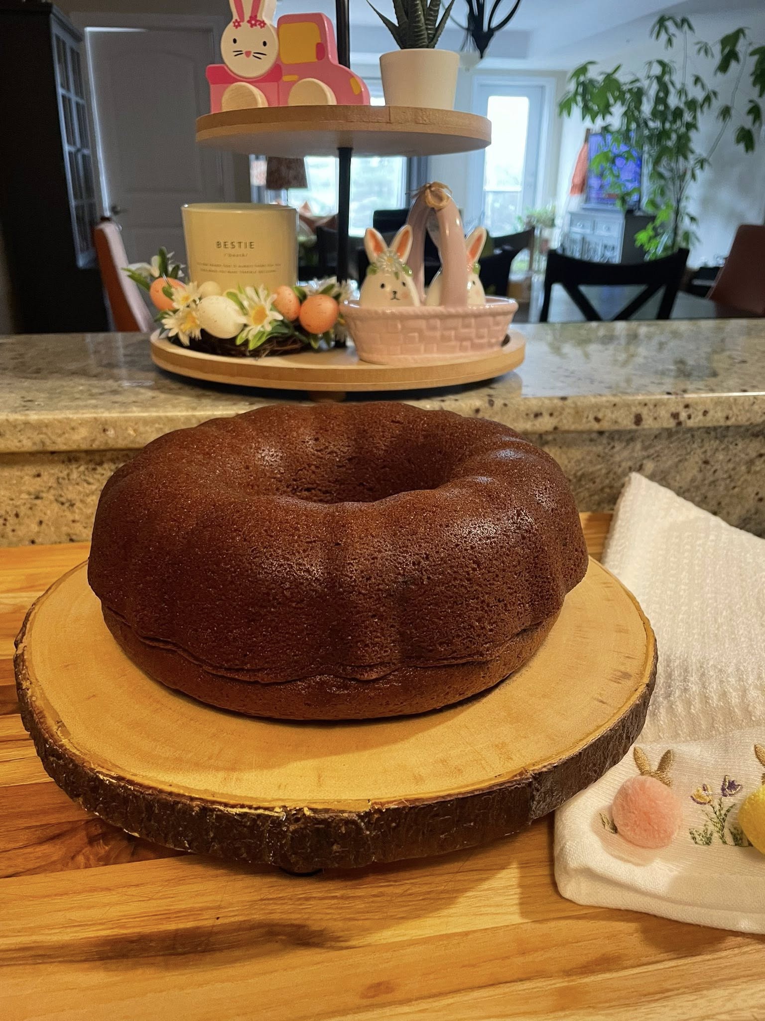 whole gingerbread bundt cake on wood slice, golden brown and ready to slice