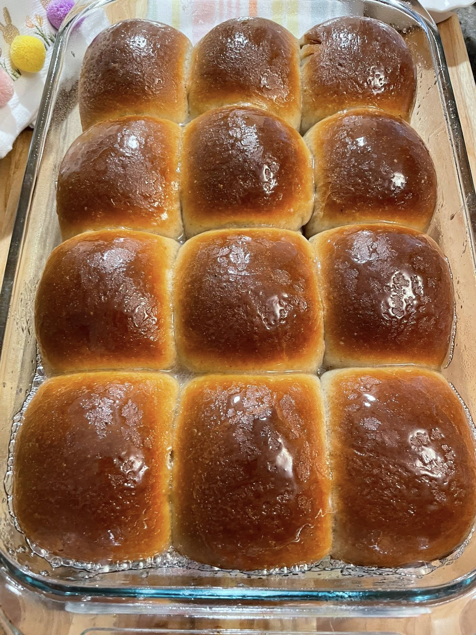 Golden brown buns just out of the oven, shiny tops.